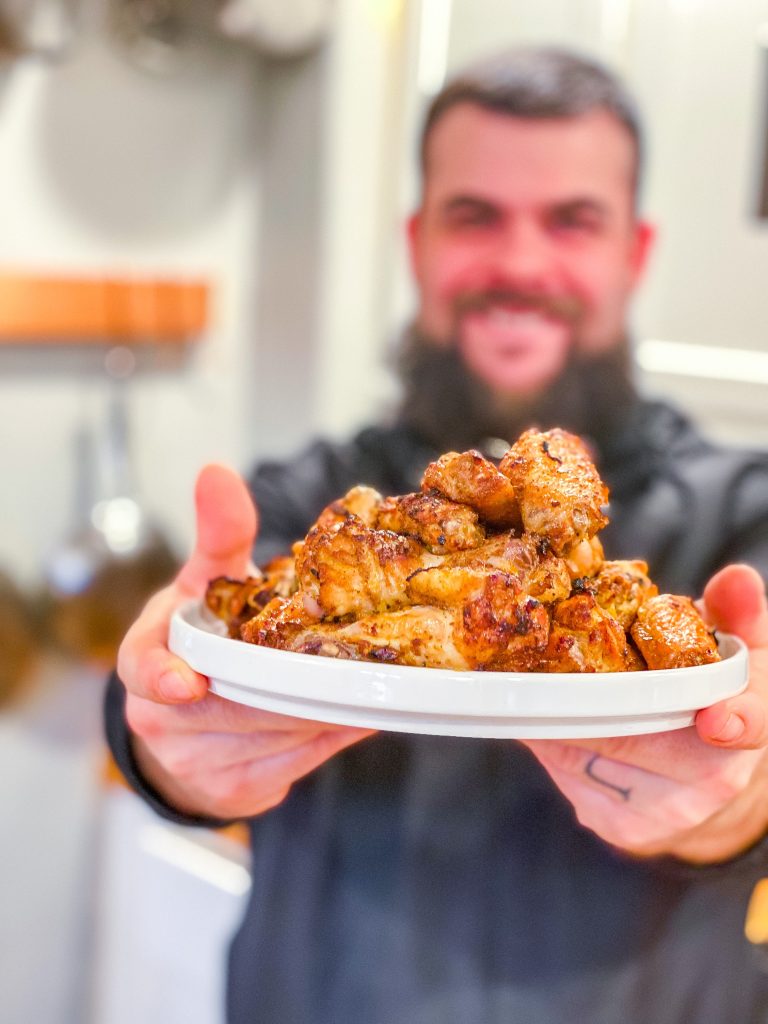Man holding plate of wings