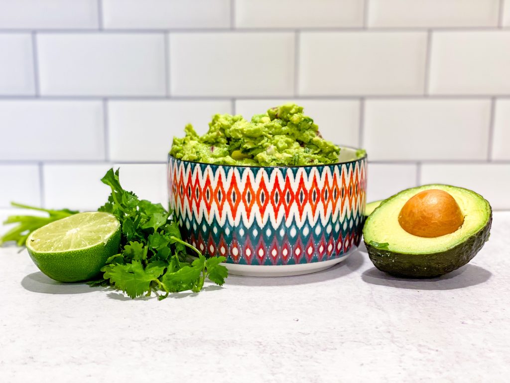 bowl of guacamole with avocado lime and cilantro 