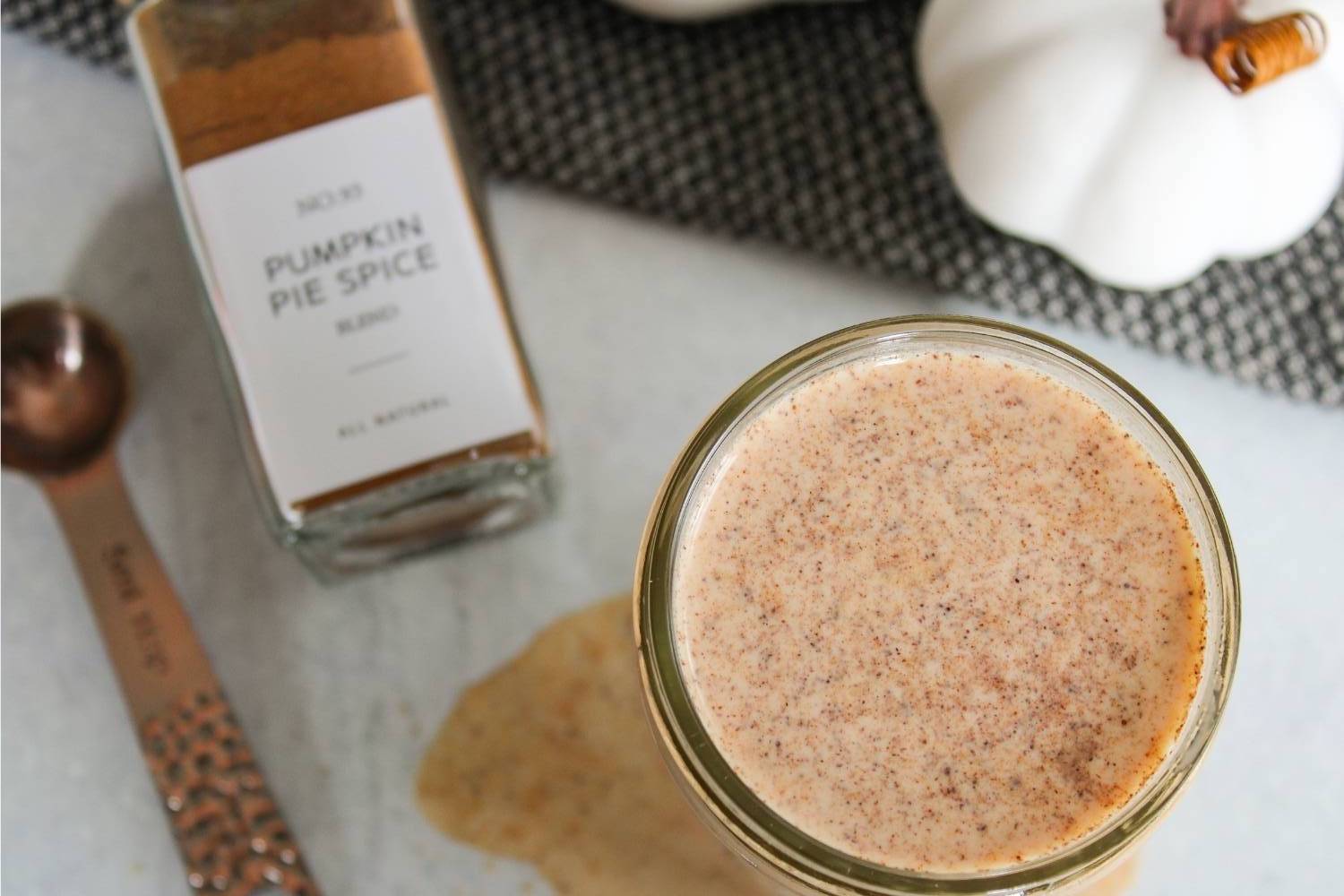 Overhear view of Pumpkin Spice Coffee Creamer next to a jar of pumpkin pie spices