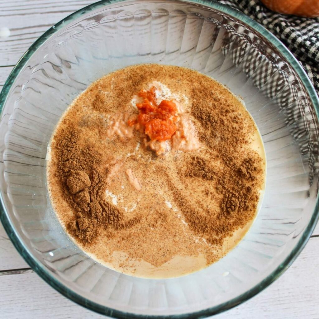Ingredients for pumpkin spice creamer added to a clear bowl. 