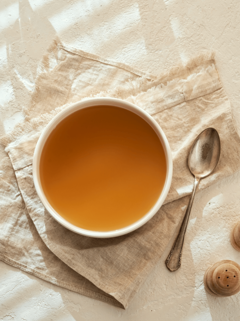 Bowl of bone broth with spoon next to it