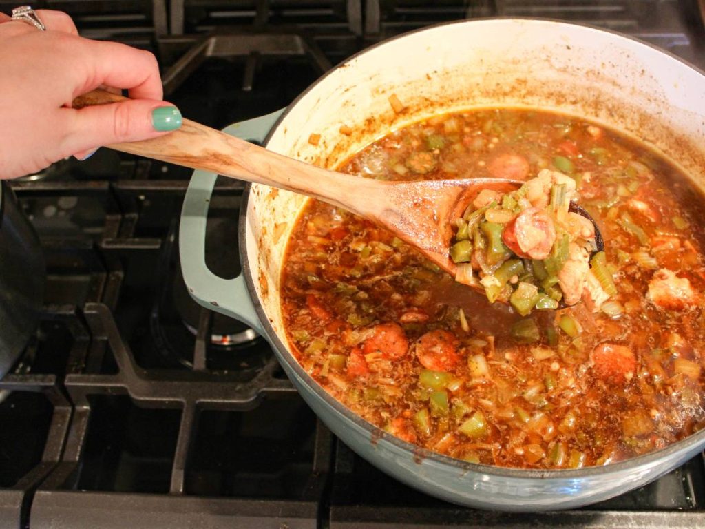 Pot of cooked gumbo with a wooden spoon