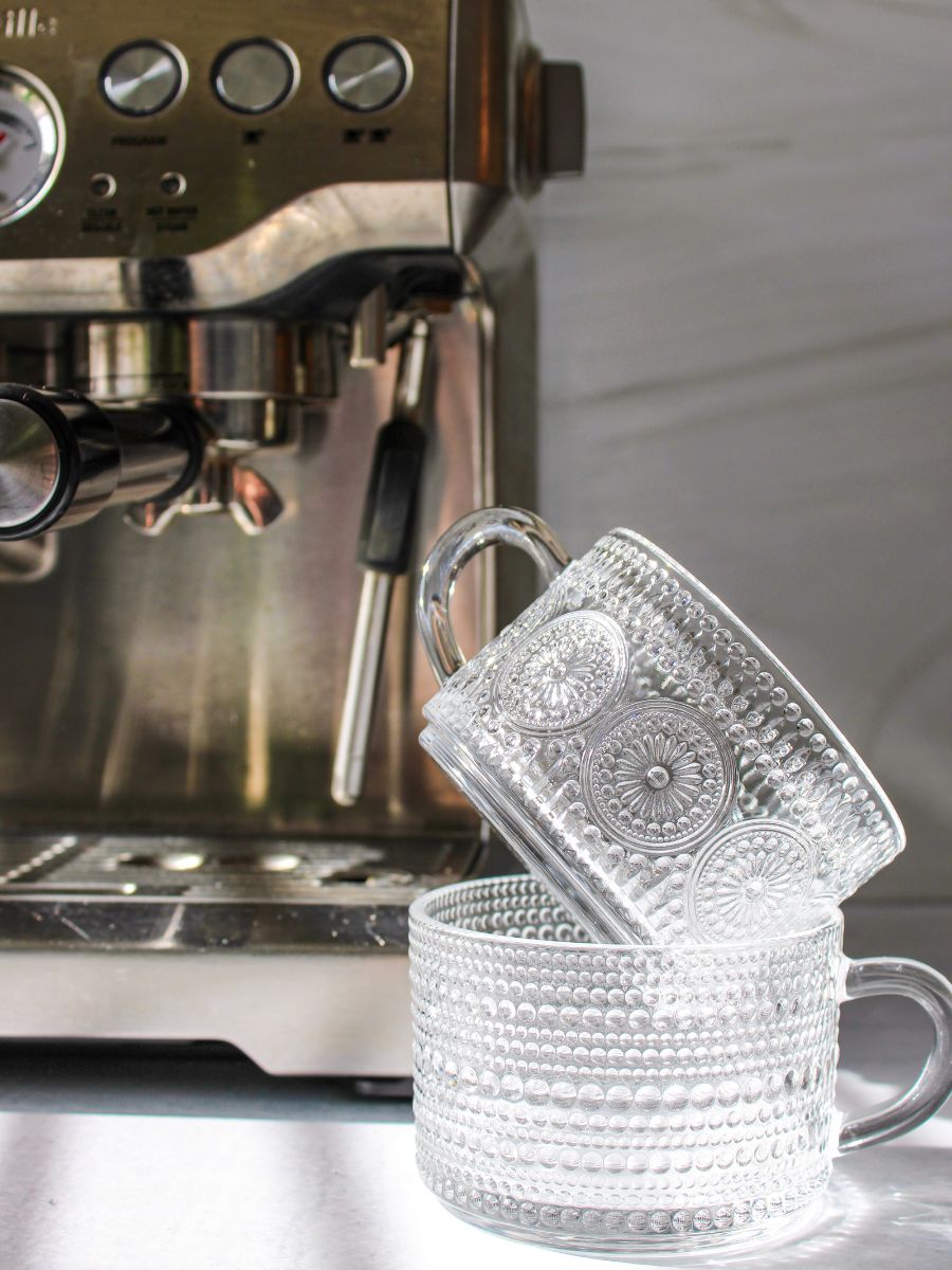 Clear glass cups with espresso machine in the background