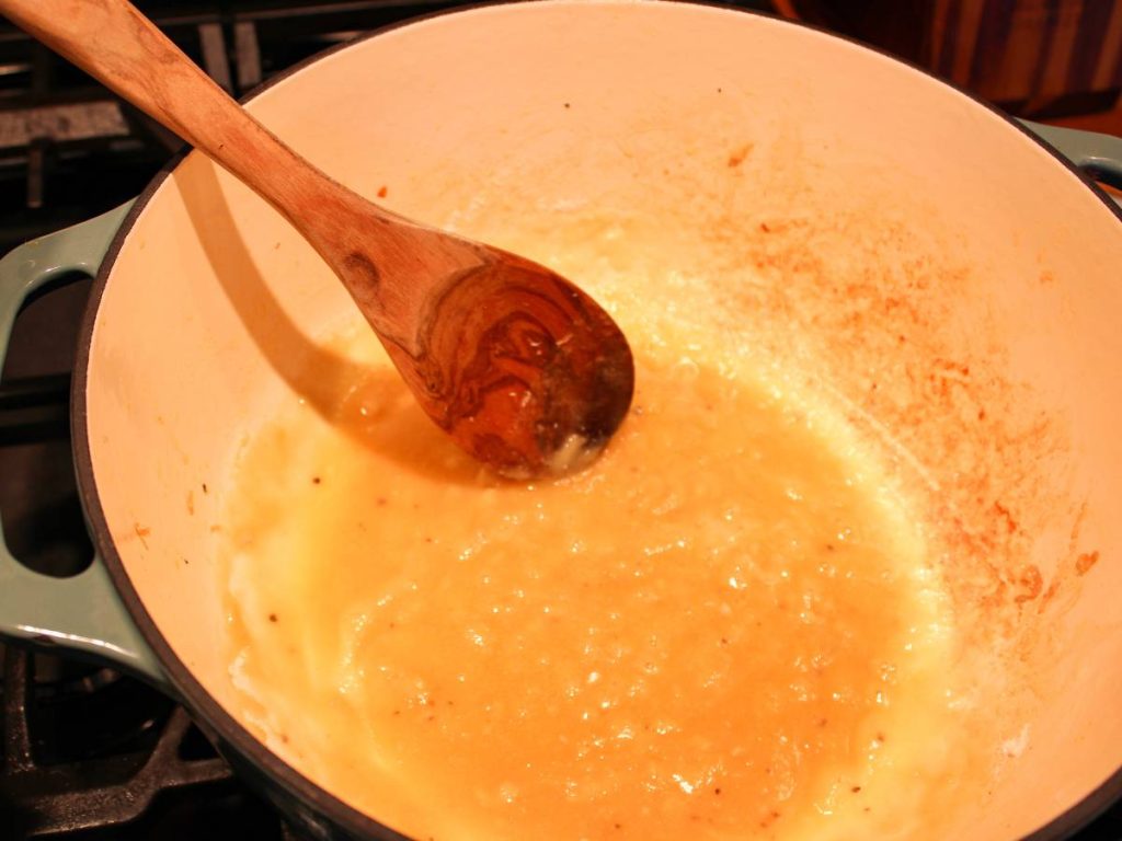 Roux cooking in a pot with wooden spoon