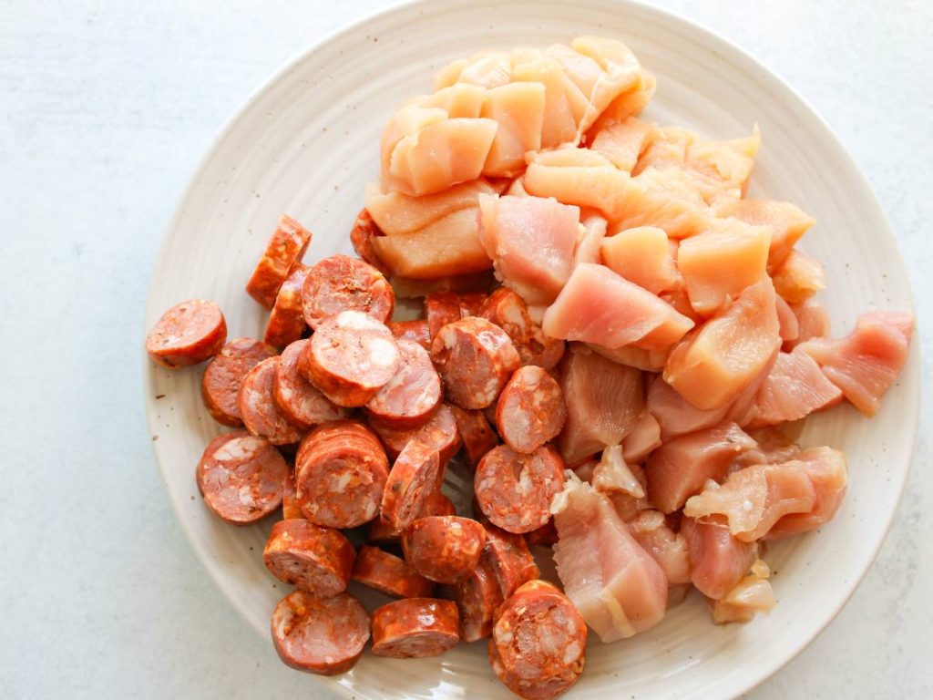 Plate with uncooked chicken and sausage