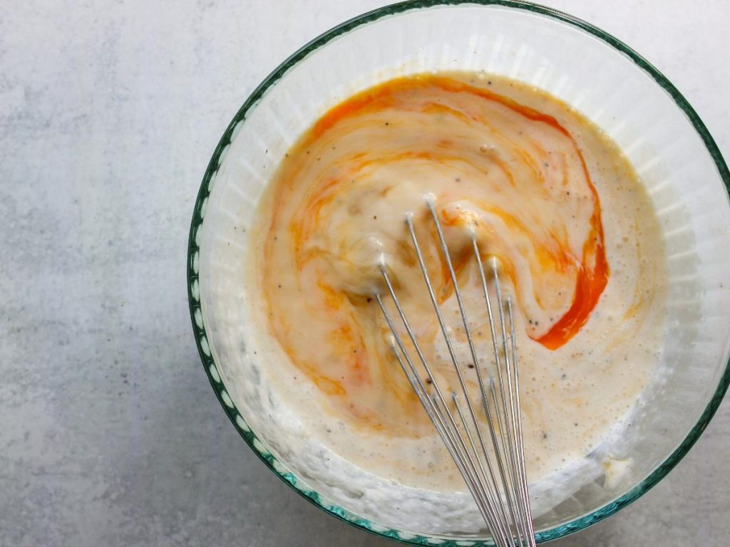 bowl of eggs and cottage cheese mixture with a whisk