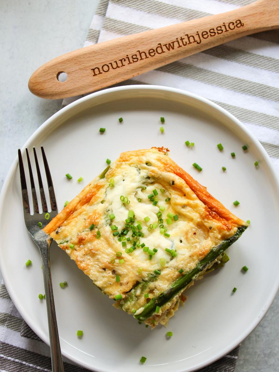 Slice of ricotta and asparagus frittata on a white plate