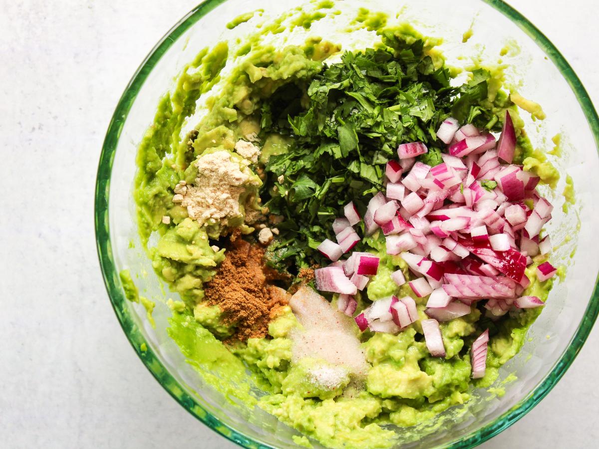 guacamole in a bowl with ingredients