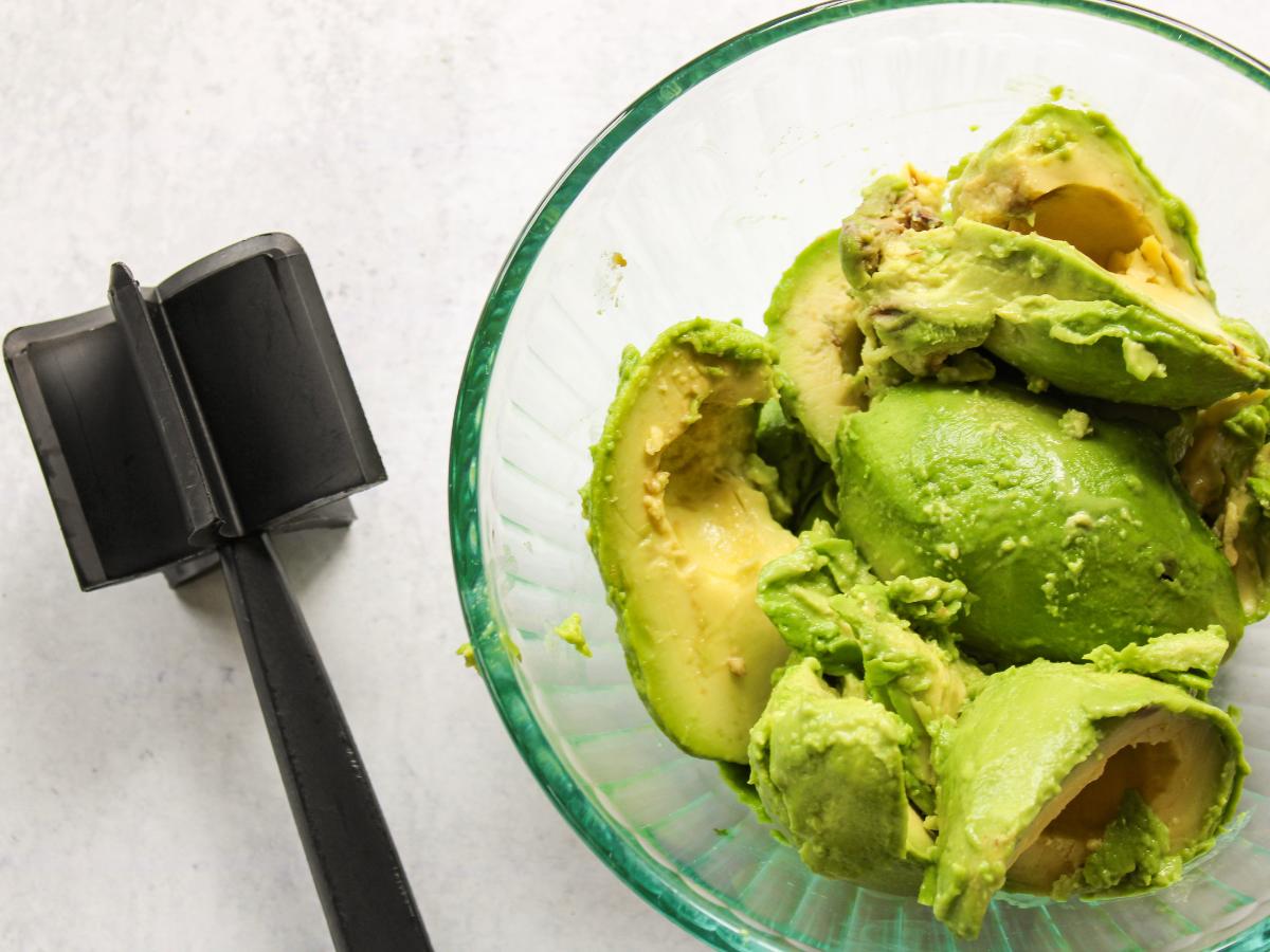 bowl of avocado with meat chopper on the side