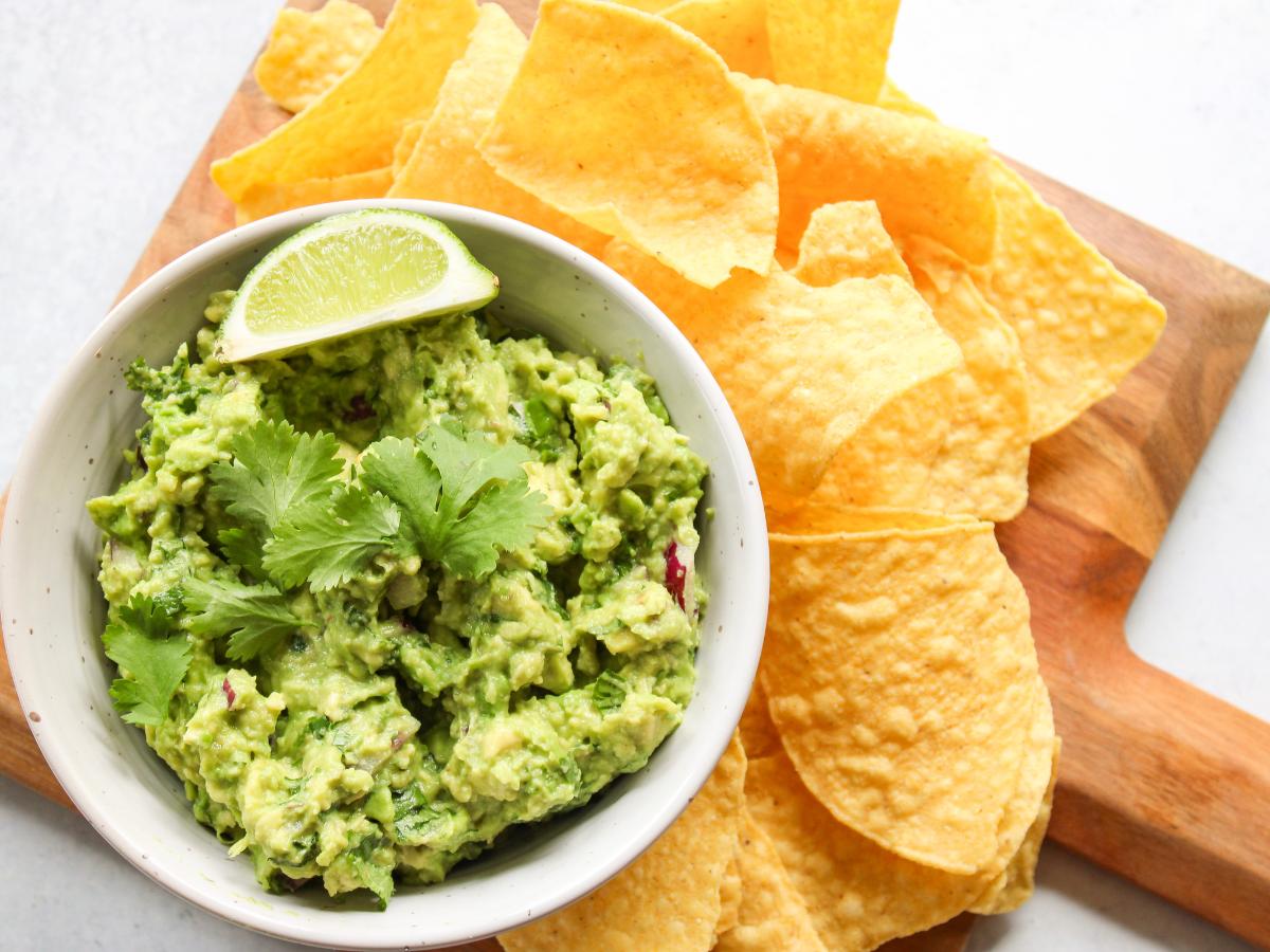 Guacamole in a bowl with chips on the side