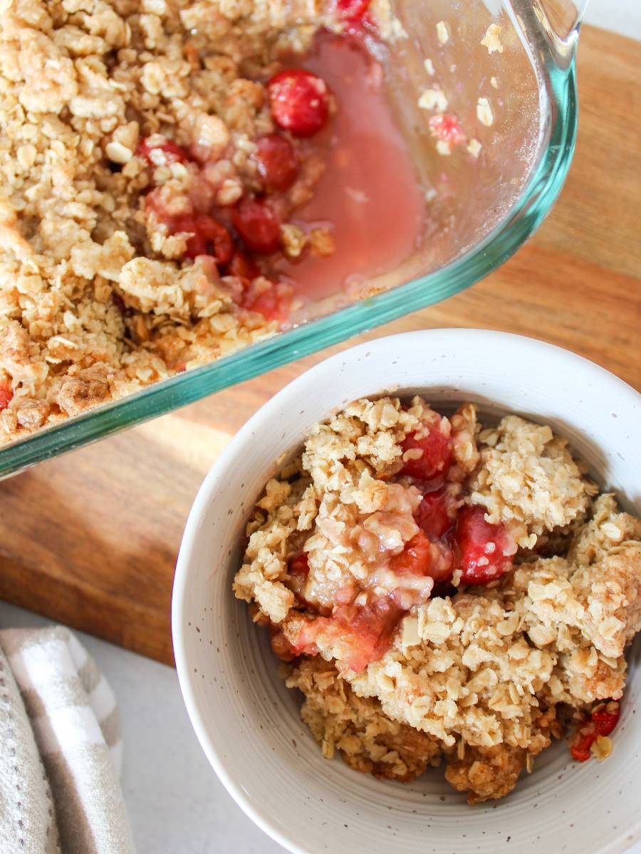 Close up of cherry crisp in a bowl and 9x13 pan