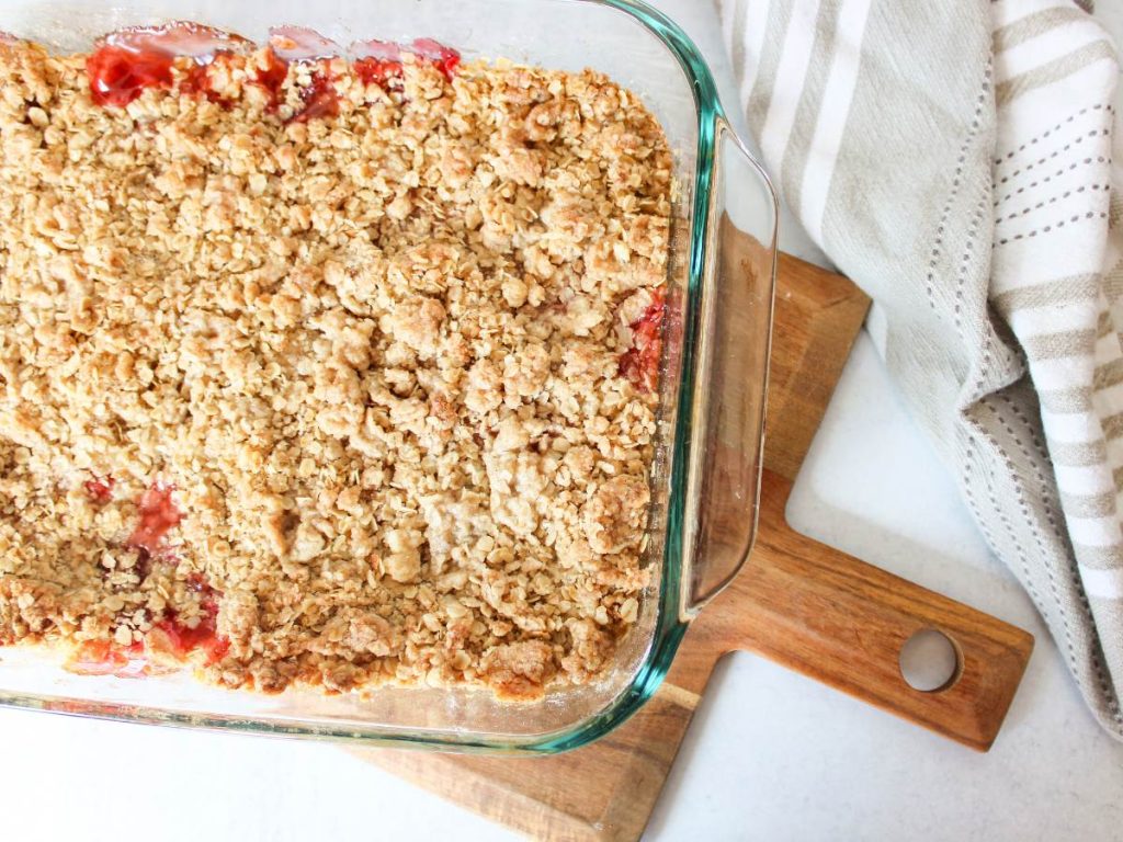 overhead view of cherry crisp in 9x13 pan on a wooden cutting board