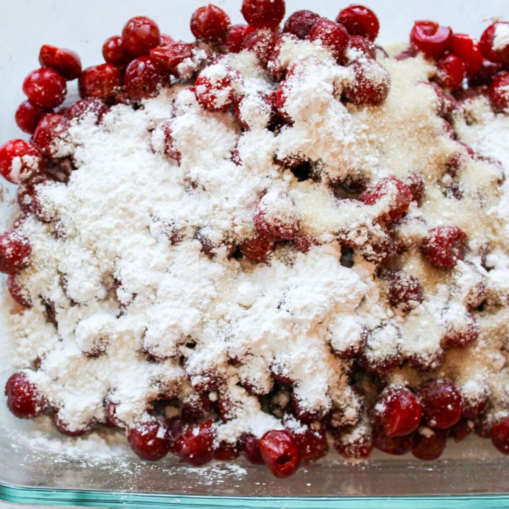 Corn starch and sugar added to tart cherries in a 9x13 pan. 