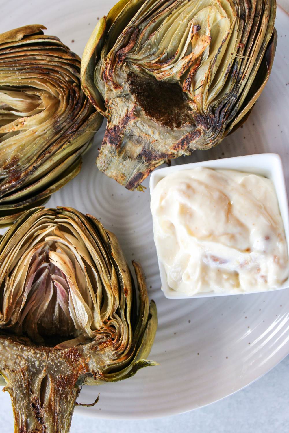 grilled artichokes with garlic aioli on a plate