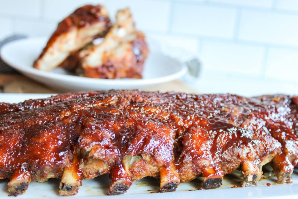 oven baked ribs next to a plate of ribs