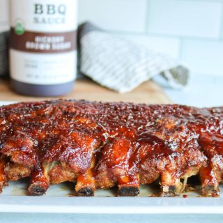 oven baked rib with bbq sauce in the background