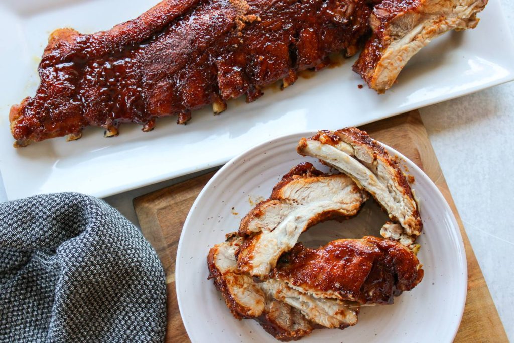 plate of ribs next to a rack of oven baked ribs