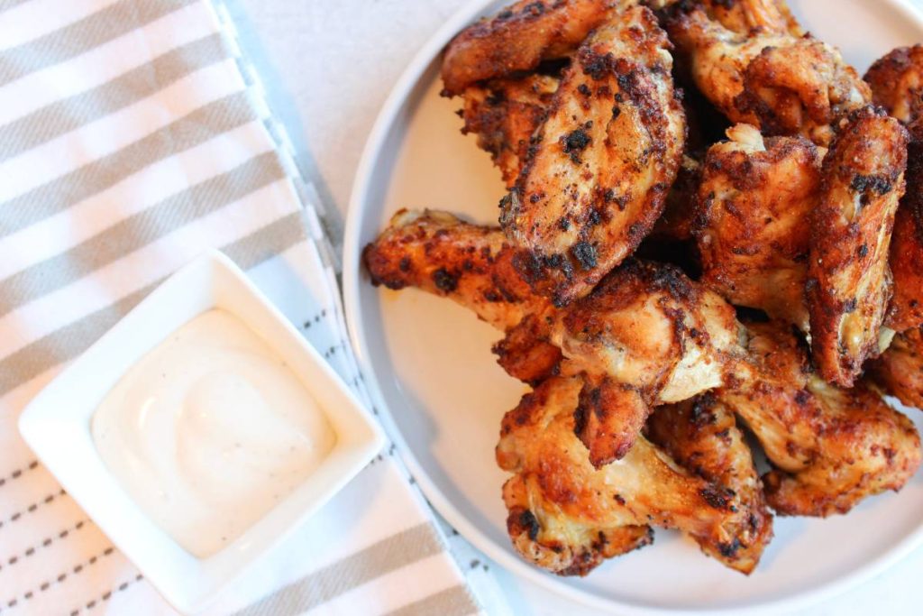 Crispy Air Fryer wings on a white plate with ranch on the side