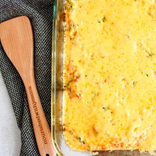 Broccoli and cheddar frittata in a 9x13 pan next to a wooden spoon