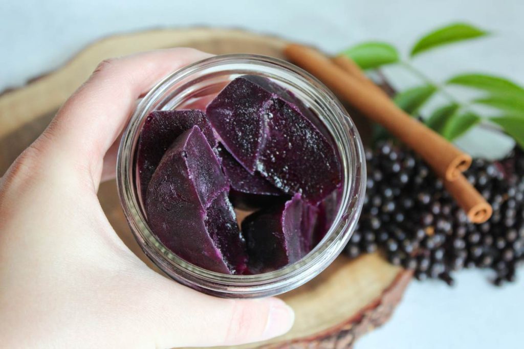 Hand holding frozen cubes of Elderberry Syrup