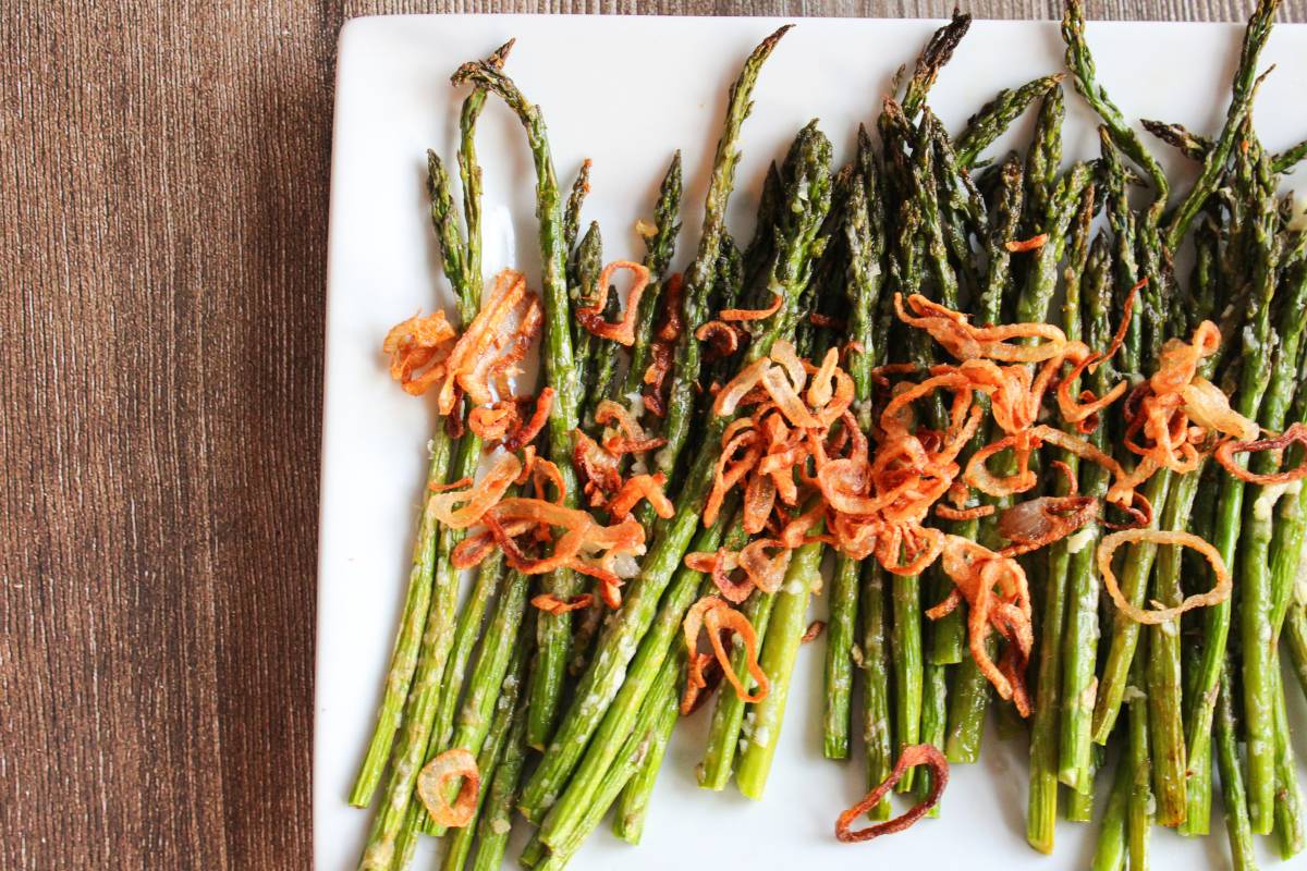 overhead view of Roasted Asparagus with Parmesan and Crispy Shallots on a white plate