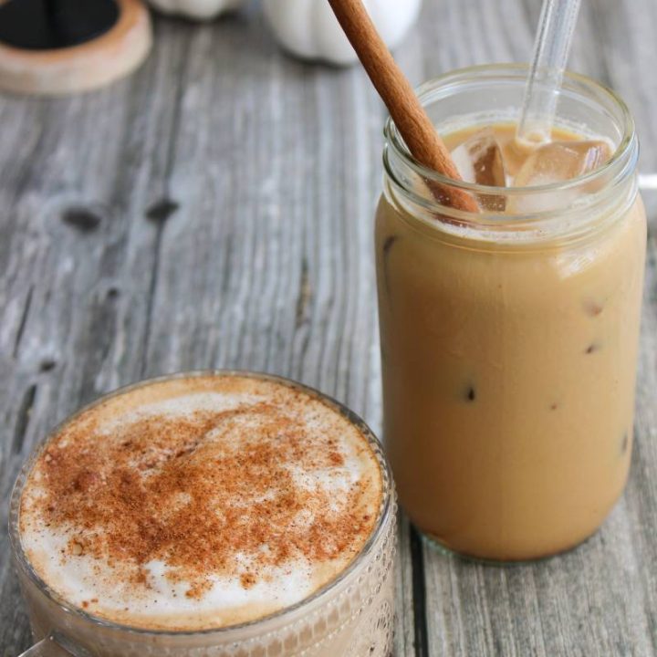 Hot pumpkin spice latte in a clear mug and an iced pumpkin spice latte in a jar