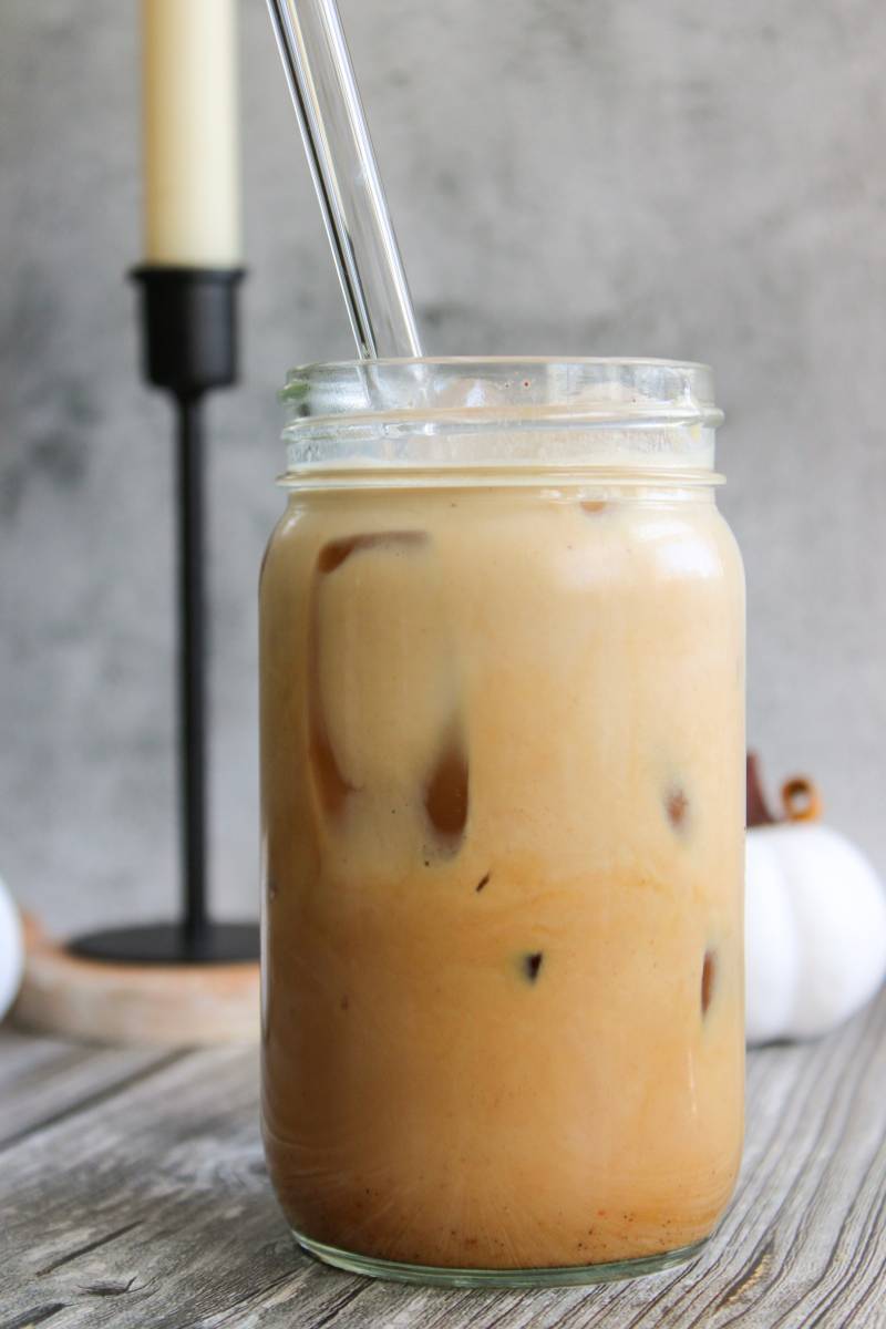 ice pumpkin spice latte in a jar with a glass straw