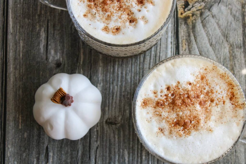 Overhead view of Pumpkin Spice Chai Lattes with a white pumpkin