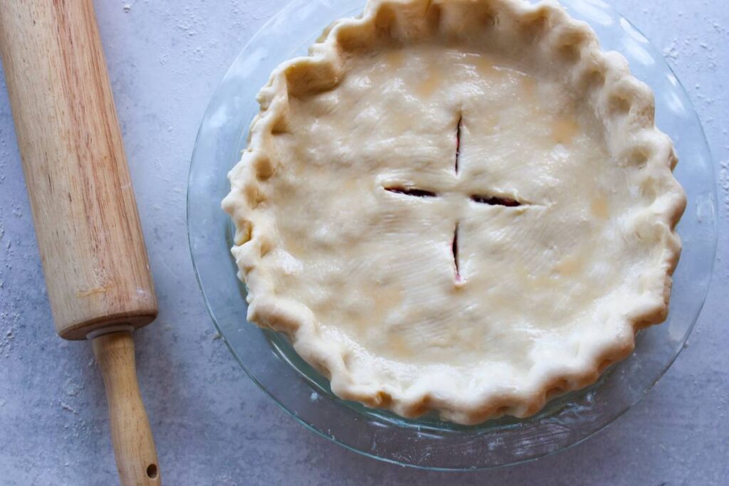 Unbaked pie next to a rolling pin