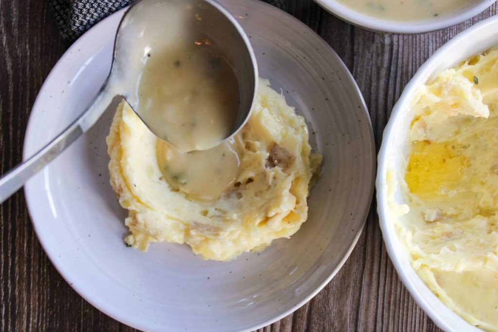 pouring gravy over mashed potatoes