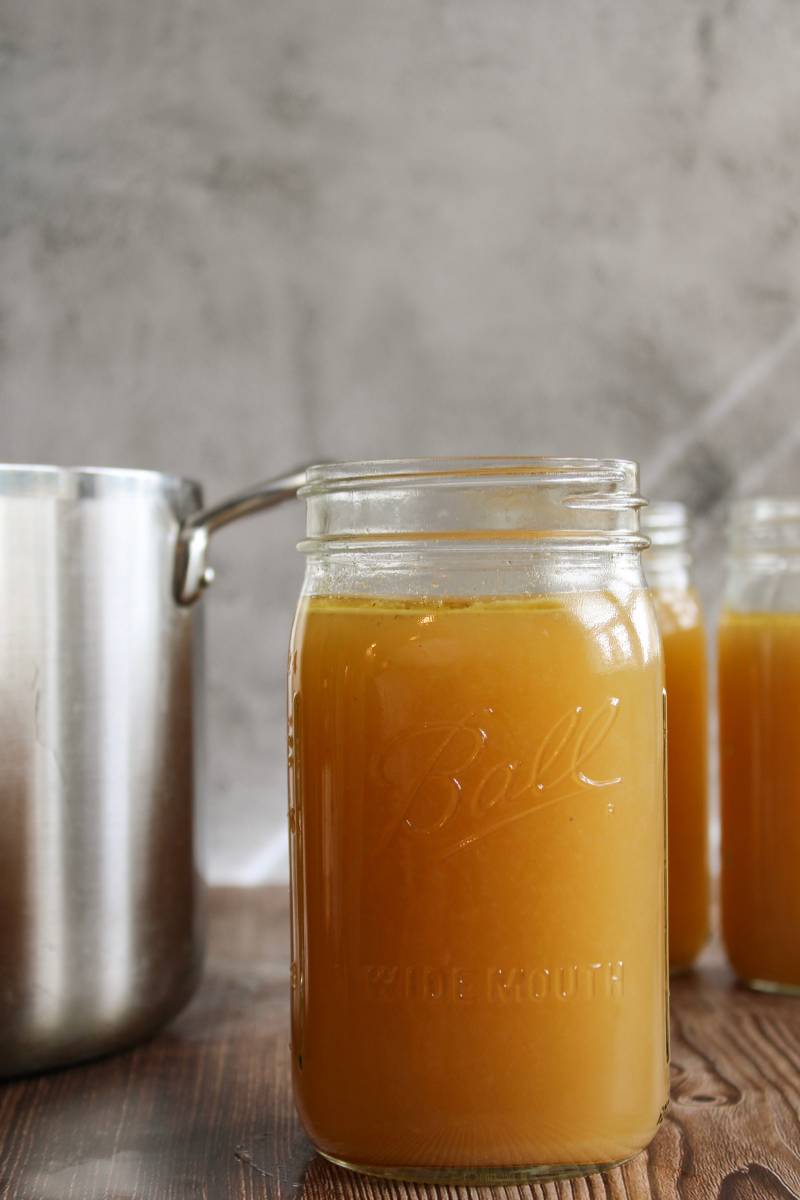 Quart jars of stock next to a large pot