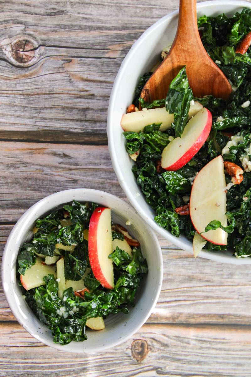 bowl of kale and apple salad next to salad bowl