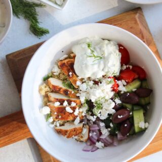 overhead view of Greek Chicken Quinoa Bowls on a wooden board