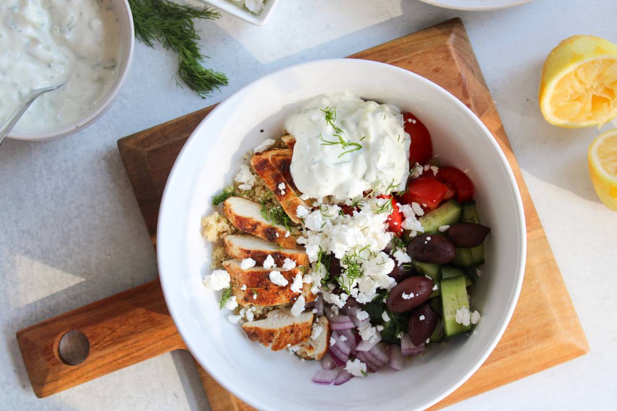 overhead view of Greek Chicken Quinoa Bowls on a wooden board