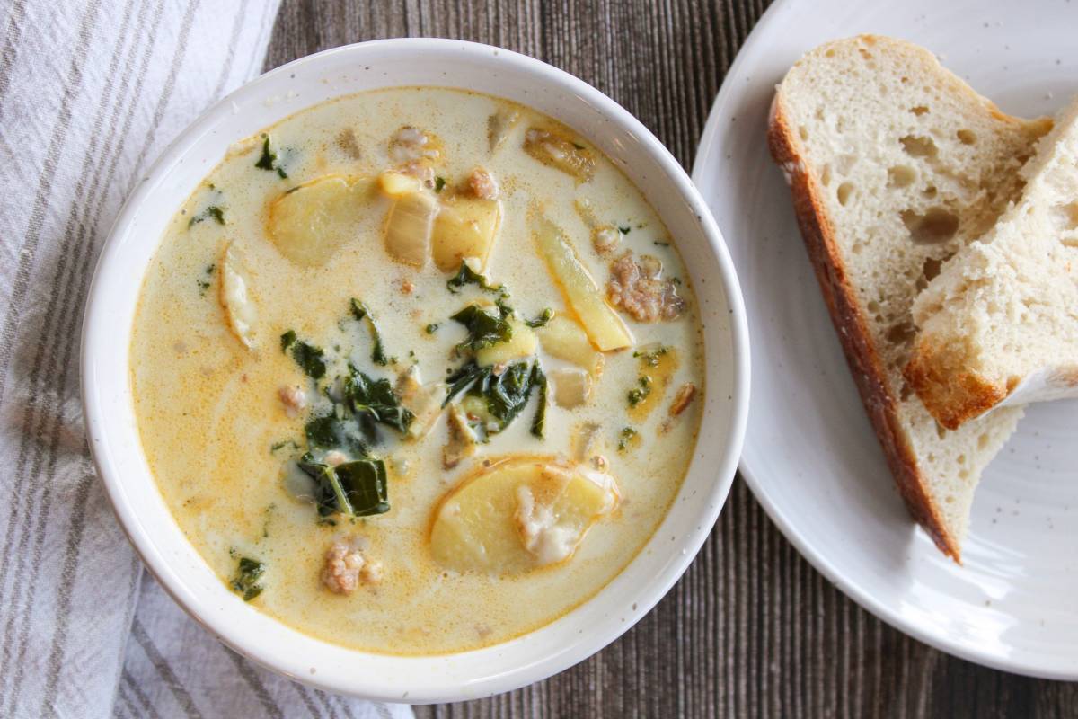 Zuppa Toscana Soup next to slices of sourdough bread