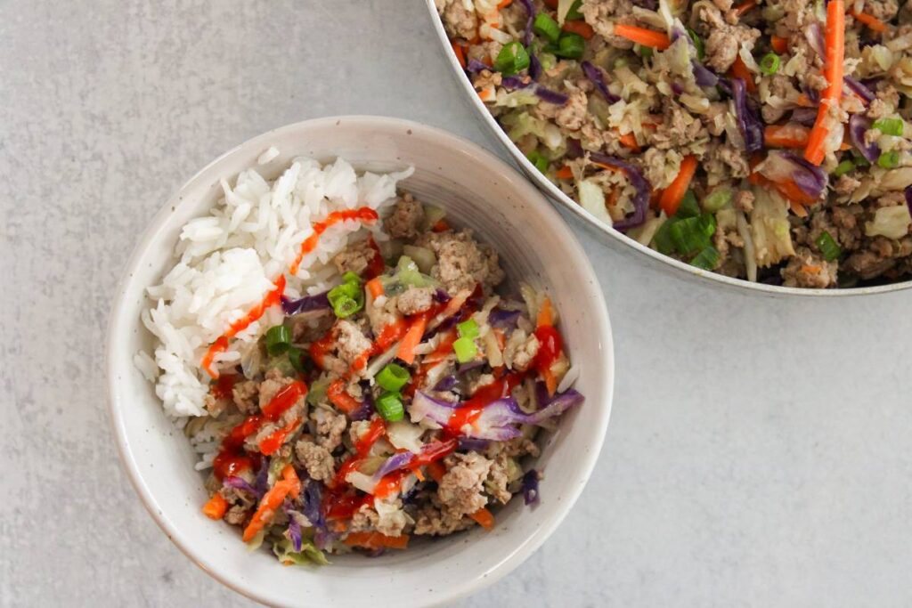 egg roll in a bowl with sriracha on top