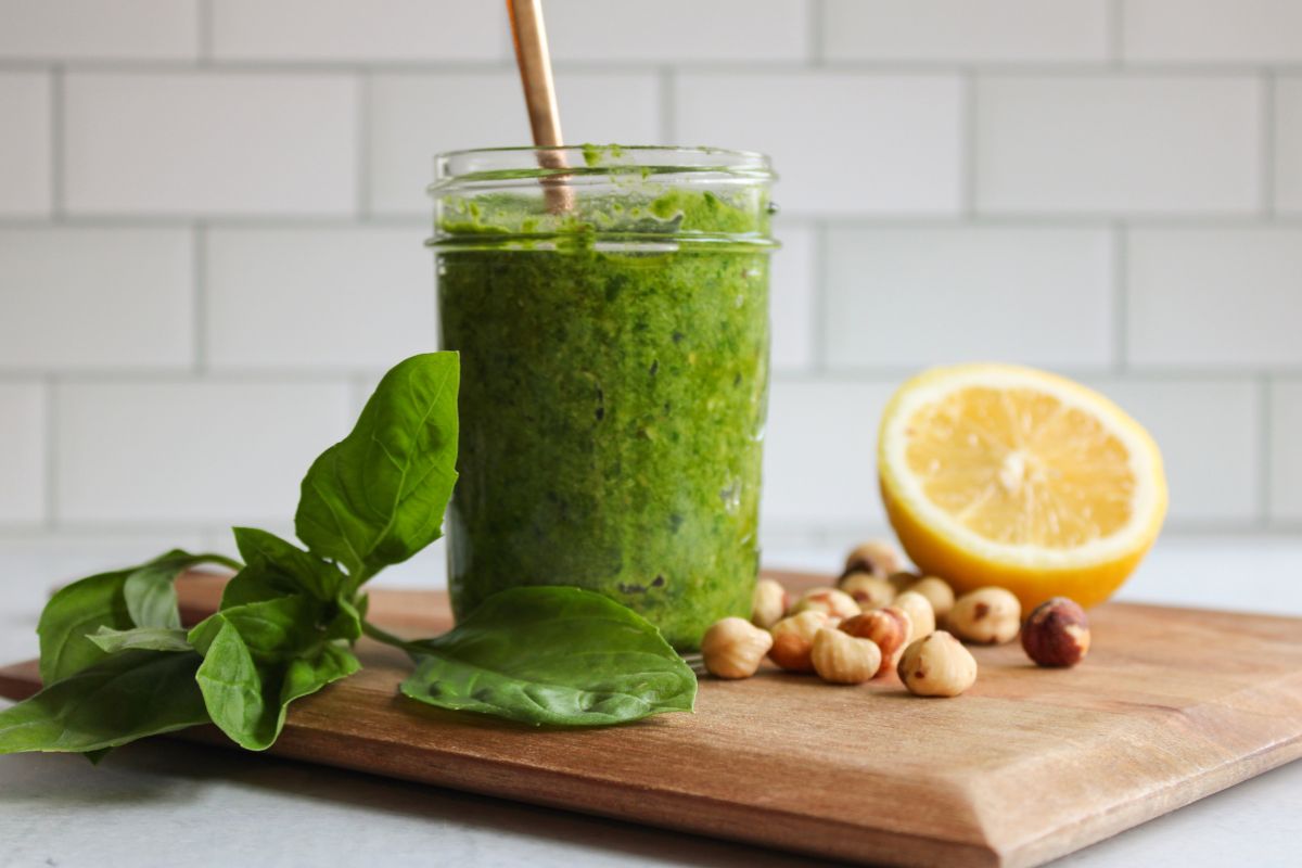 a small mason jar filled with hazelnut pesto with a gold spoon