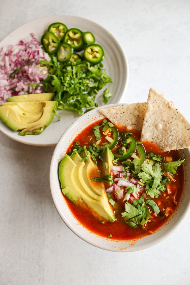 instant pot chicken tortilla soup next to a plate of toppings