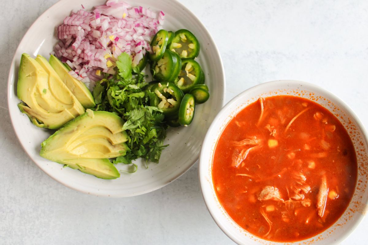 toppings next to a plain bowl of chicken tortilla soup