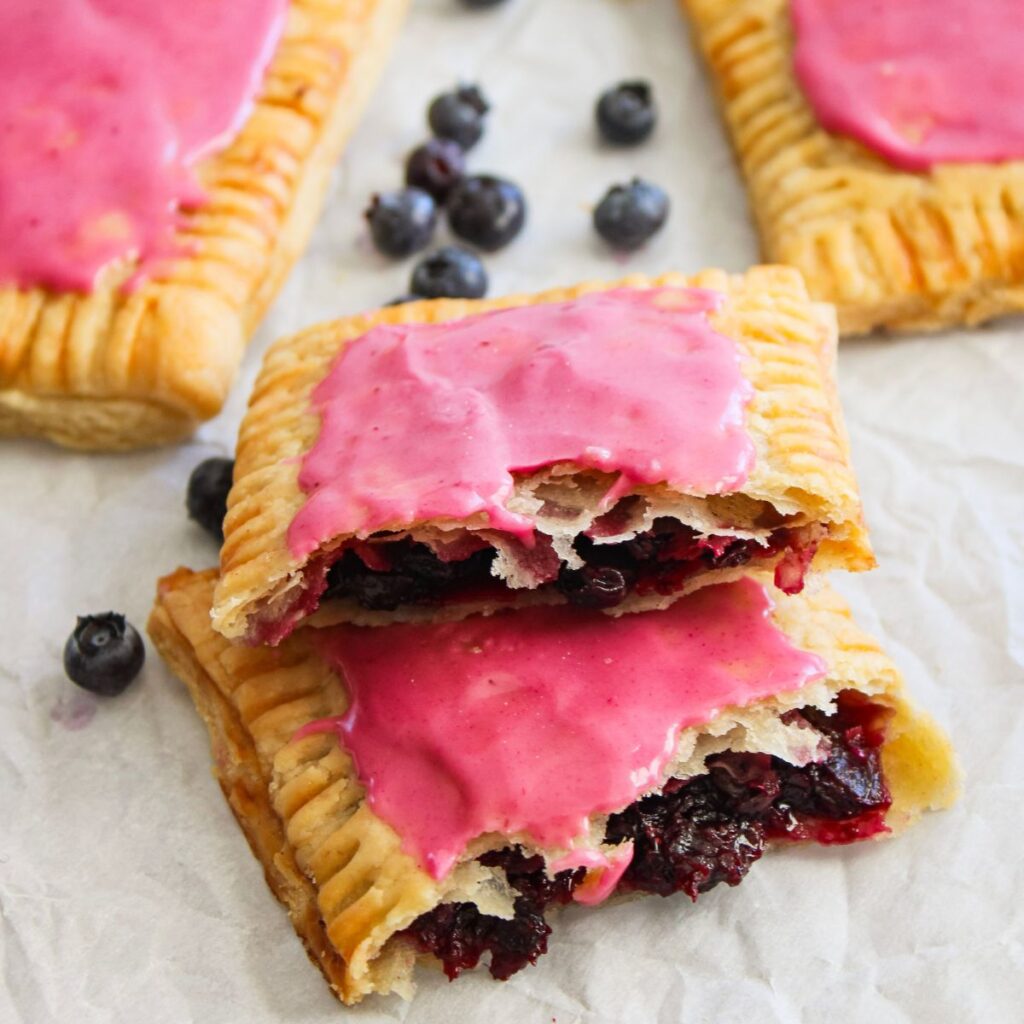 Two halves of homemade blueberry pop tarts stacked on top of each other