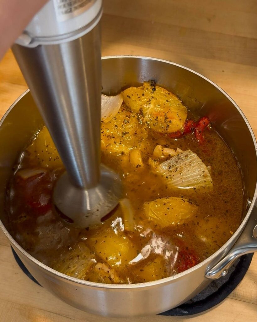 Immersion blender blending up the ingredients for Roasted Tomato Soup.