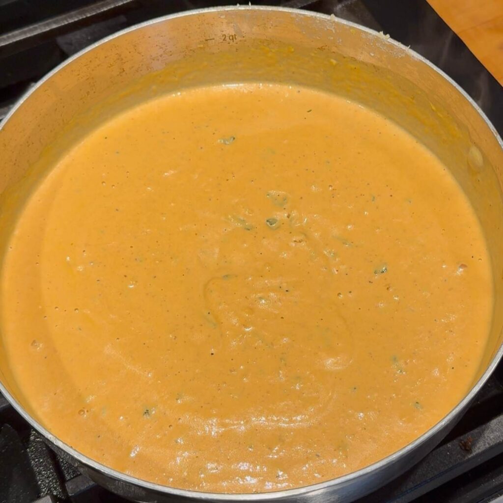 Creamy pumpkin pasta sauce coming to a low boil.