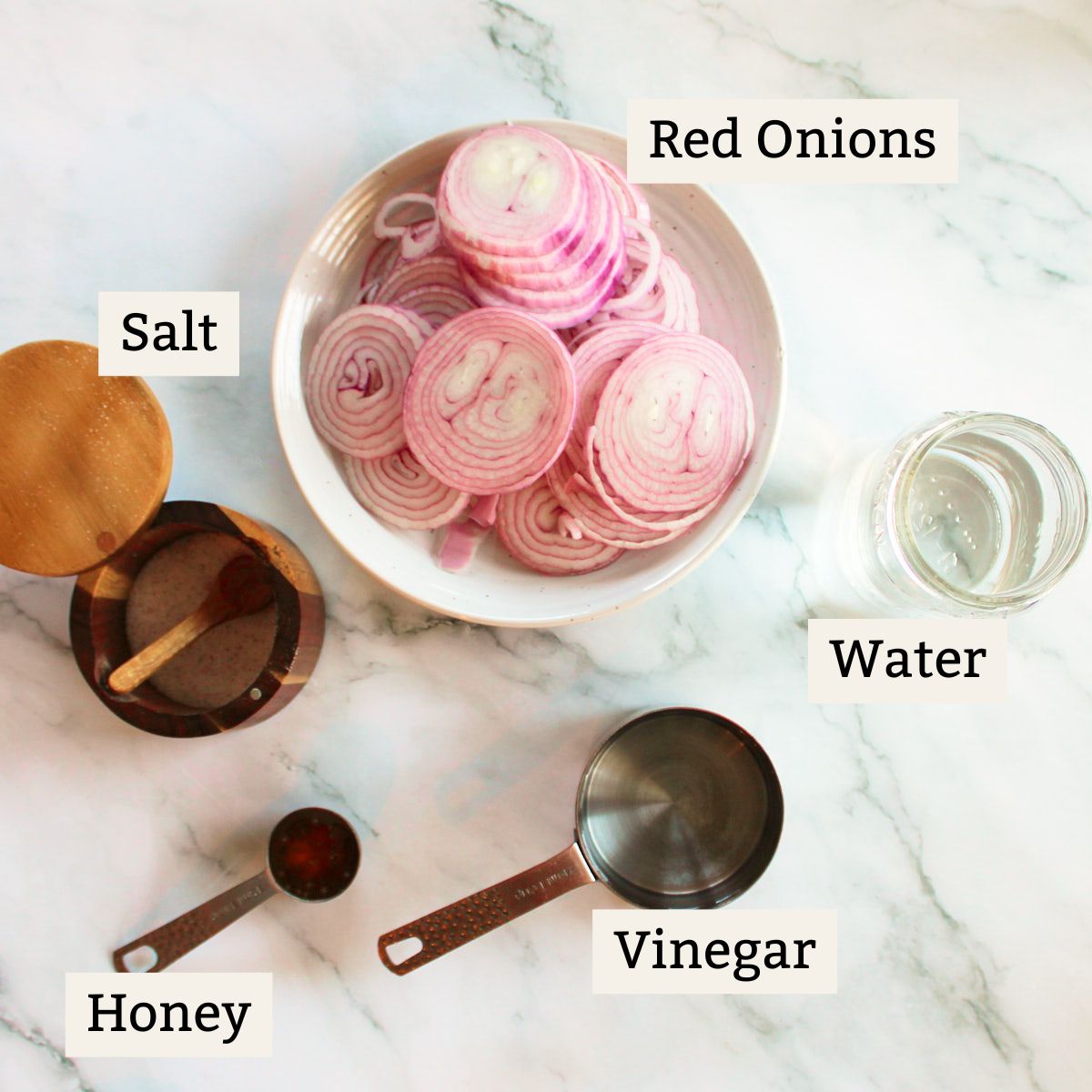 Ingredients for quick pickled red onions on a white background.