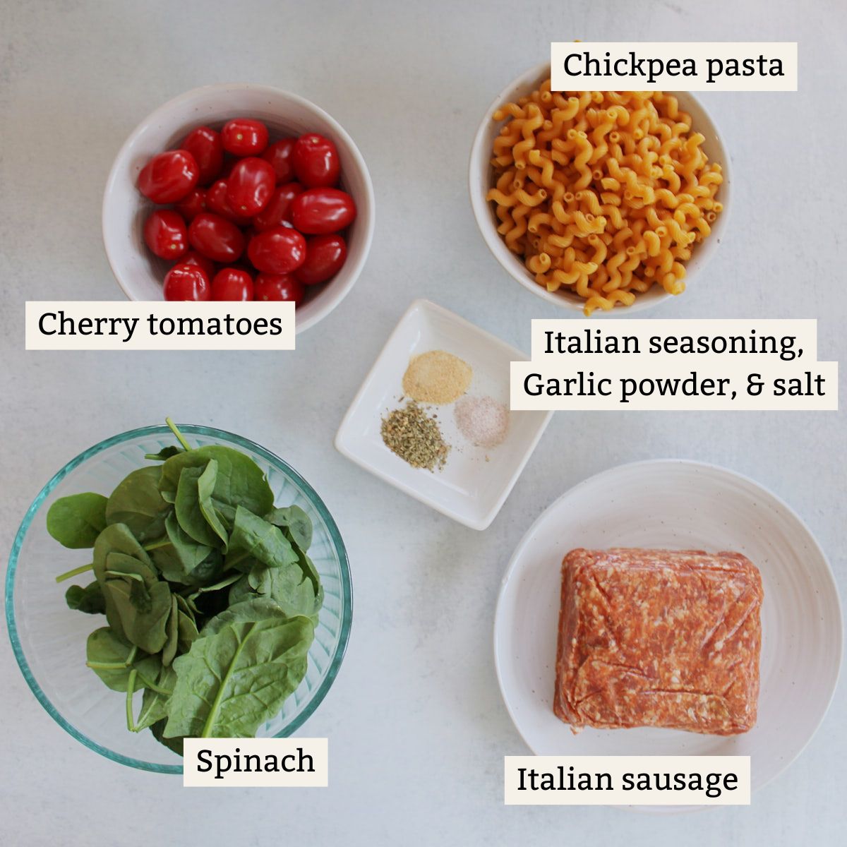 Ingredients for high protein pasta in white bowls on a white background.
