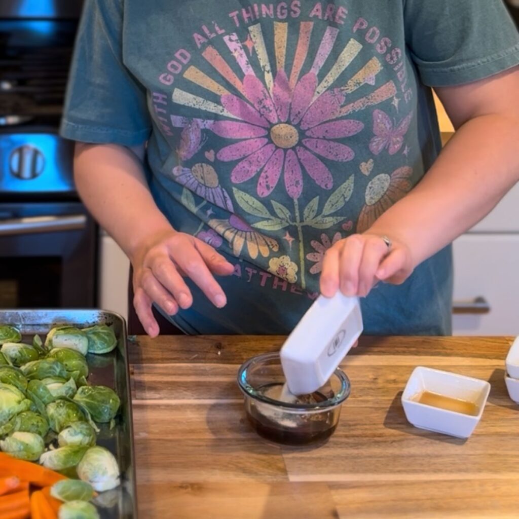 A woman making the sauce to go on the chicken and vegetables for the sheet pan dinner.